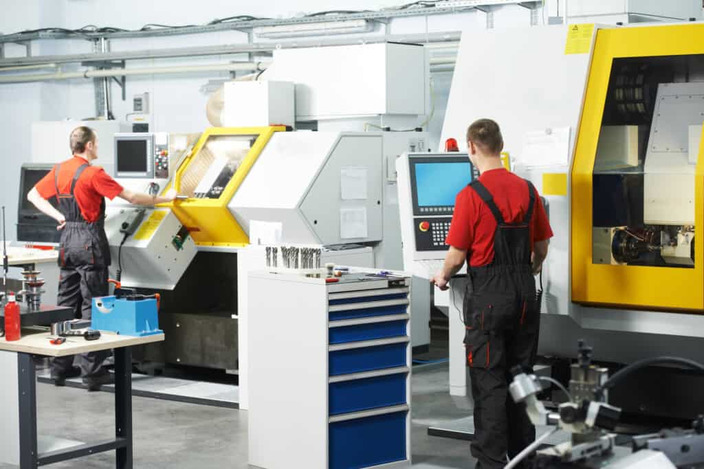 Backside Of Two Employees Working At A Tool Workshop